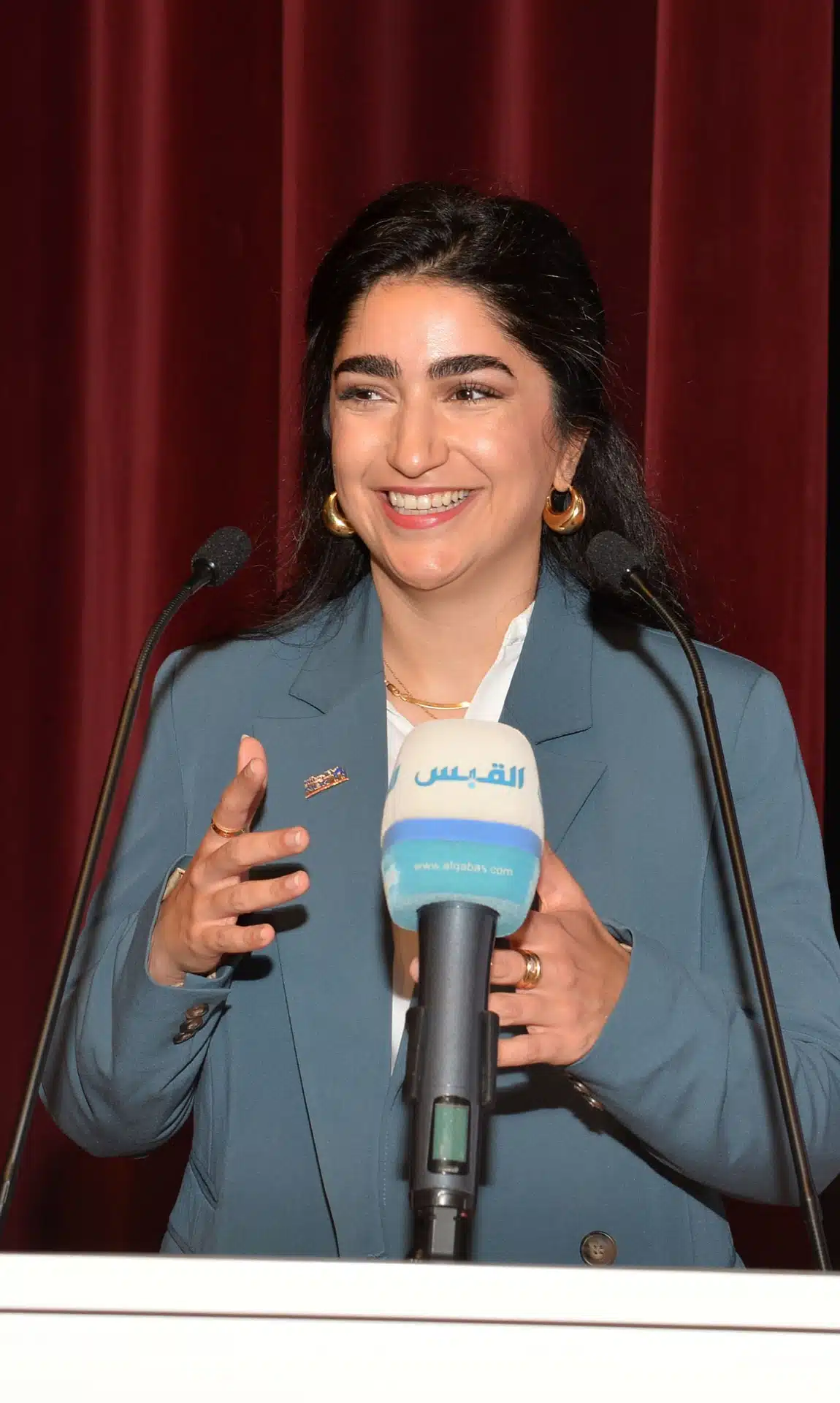 متحدثة تتحدث للحضور بابتسامة